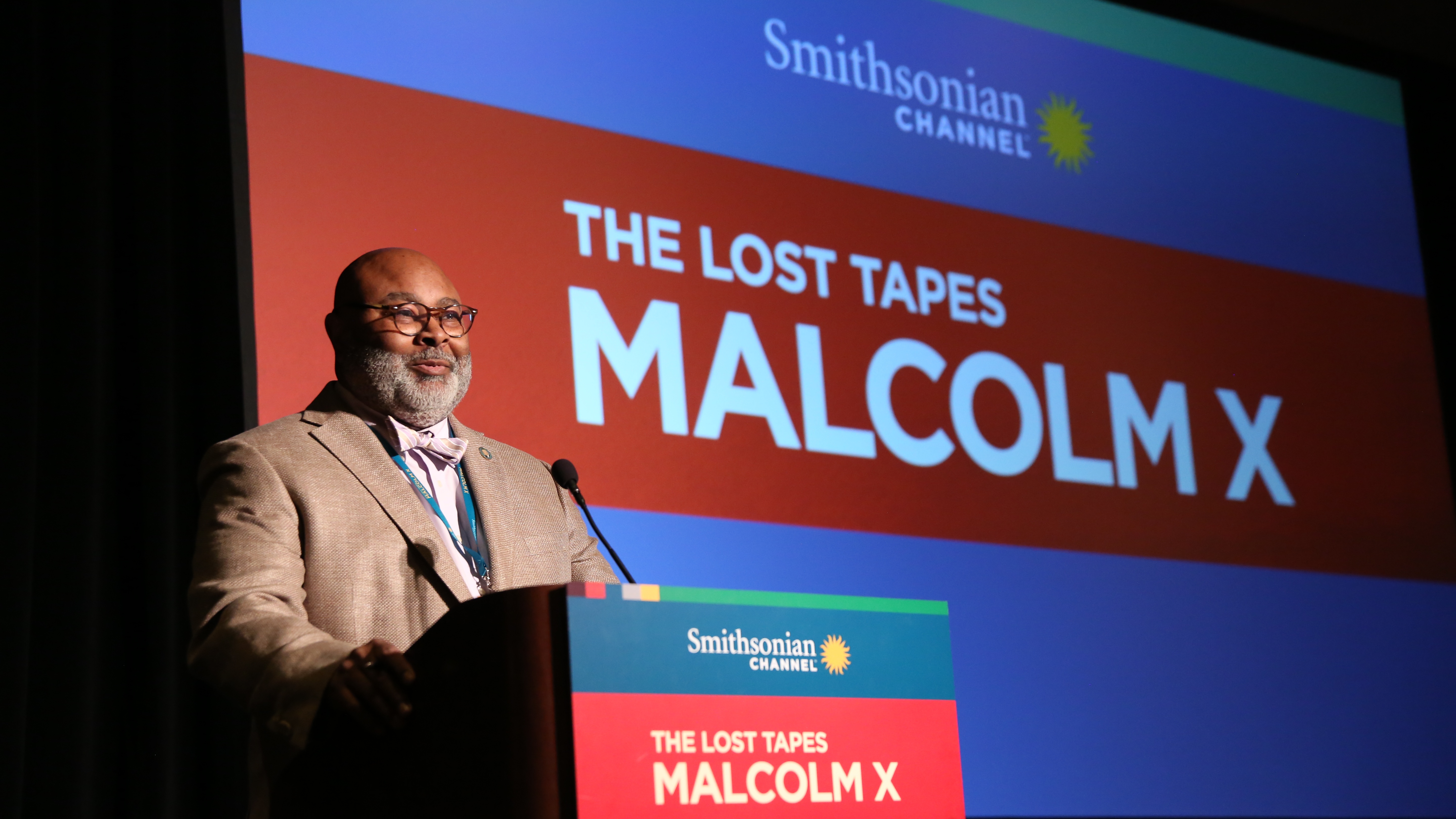 A man standing behind a podium onstage.